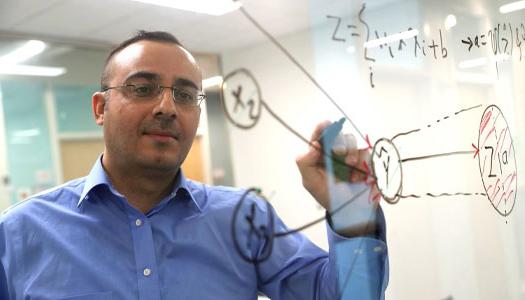 a teacher writes on a transparent white board 